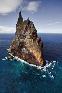 Rock formation in sea against sky