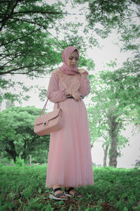 Woman standing by tree on field