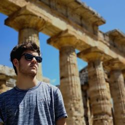 Man wearing sunglasses against old ruins