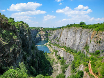 Scenic view of waterfall in forest against sky