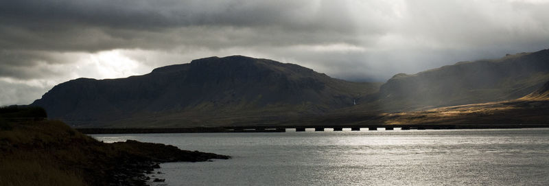 Scenic view of sea and mountains against sky