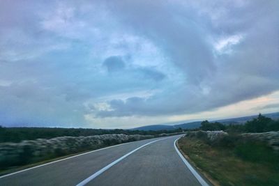 Empty road against cloudy sky