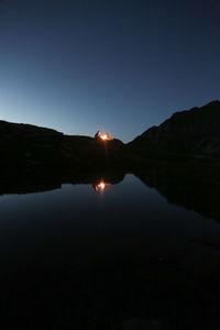 Scenic view of lake against sky at night