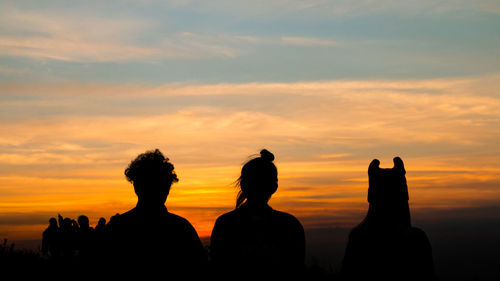 Silhouette of people against sky during sunset