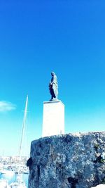 Low angle view of statue against clear blue sky