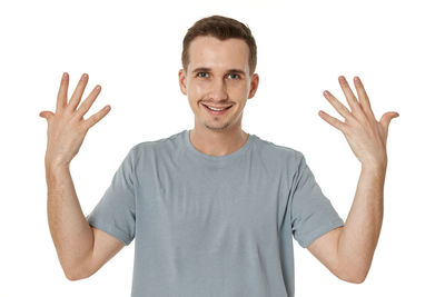 Portrait of young man gesturing against white background