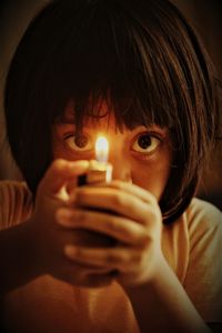 Close-up of girl blowing sparkler at night