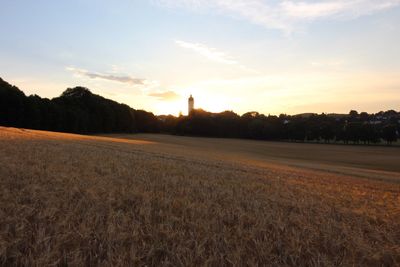 Scenic view of field against sky at sunset