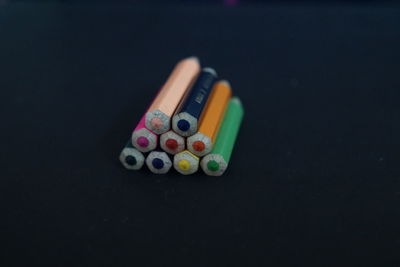 Close-up of colored pencils on table against black background