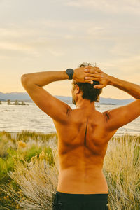 Young man standing in tall grass near mono lake in northern california