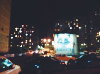 Defocused image of illuminated city against sky at night