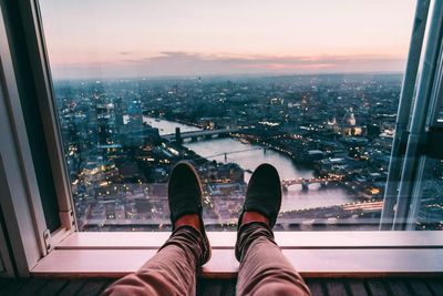 Low section of man on window against city 