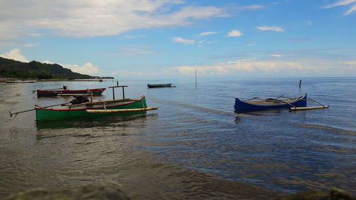 Boat moored in sea against sky