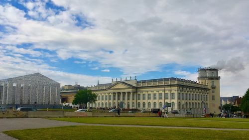 Buildings in city against cloudy sky