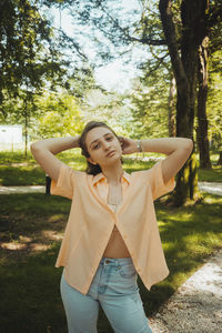 Portrait of smiling young woman standing in park