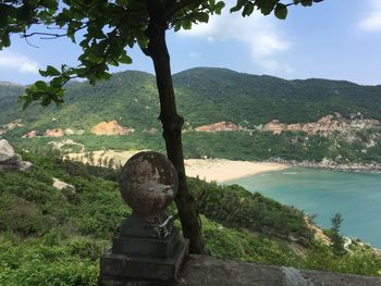 Scenic view of river by mountains against sky
