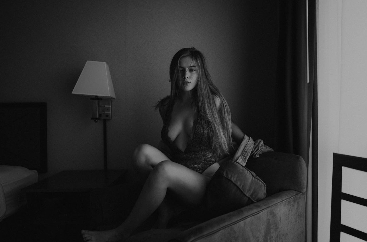one person, black, sitting, indoors, women, adult, domestic room, long hair, young adult, hairstyle, black and white, furniture, home interior, white, full length, lifestyles, darkness, portrait, bedroom, blond hair, monochrome, monochrome photography, domestic life, underwear, clothing, person, bed, fashion, lingerie, emotion, looking, female, photo shoot, relaxation, loneliness