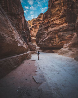 Rear view of man walking on rocks