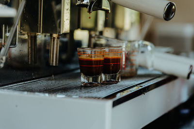 Espresso shot coffee flows from the coffee machine.