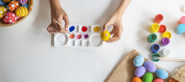 High angle view of woman playing with multi colored pencils on table