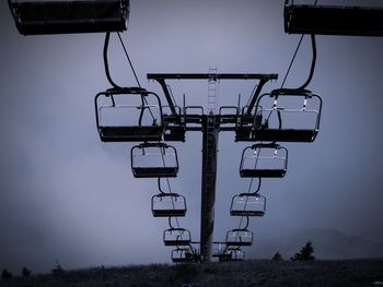 Low angle view of ski lift on field against sky
