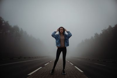 Full length of woman standing on road
