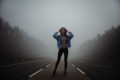 Foggy morning on the road through a pine forest