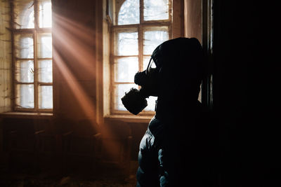 Side view portrait of silhouette man sitting at home