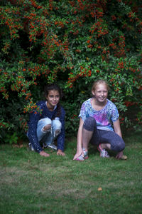 Happy friends sitting on field