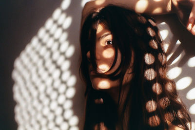 Close-up of thoughtful woman looking away against wall