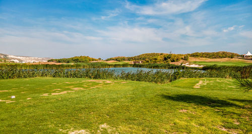 View of grassy field against cloudy sky