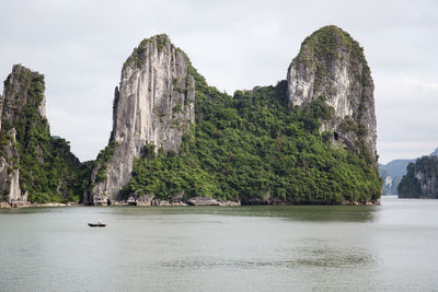 Rock formations in sea against sky