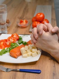 Cropped hand of person preparing food on table