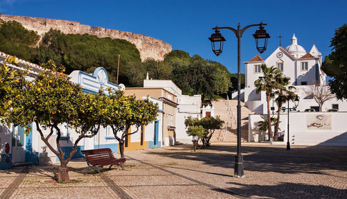 Footpath by church and buildings during sunny day