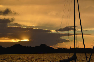 Silhouette sailboat on sea against sky during sunset