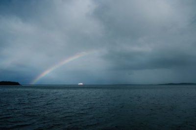 Scenic view of rainbow over a ship and sea against sky