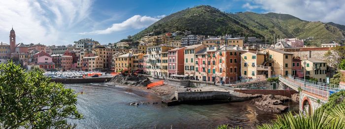 Panoramic view of townscape by river against sky