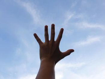 Low angle view of hand against sky