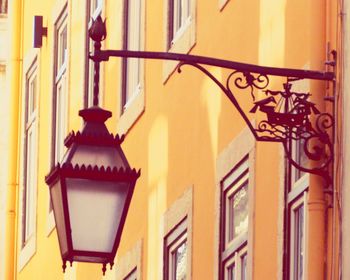 Low angle view of lantern hanging on wall of building