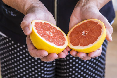 Midsection of person holding grapefruit