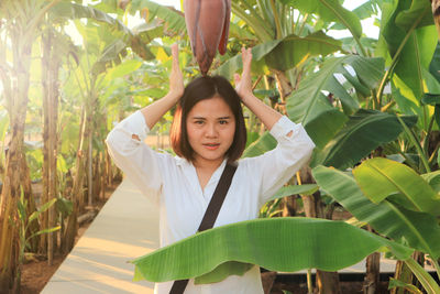 Asian woman and banana blossom in the garden.