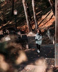 Rear view of woman standing by trees