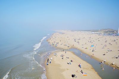 Panoramic view of people on beach against sky