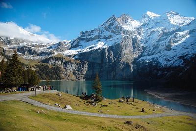 Scenic view of lake by snowcapped mountains against sky