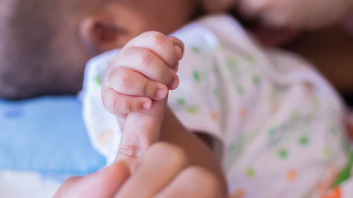 Close-up of baby hands on bed