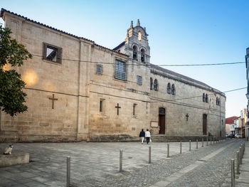 Street amidst buildings in city against clear sky