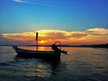 Silhouette boat in sea against sky during sunset