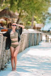 Full length of young woman wearing sunglasses standing outdoors