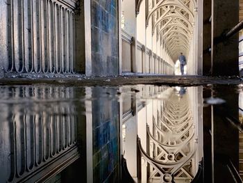 Reflection of bridge in puddle