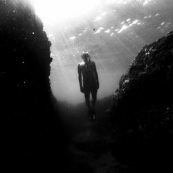 Rear view of silhouette man swimming in sea